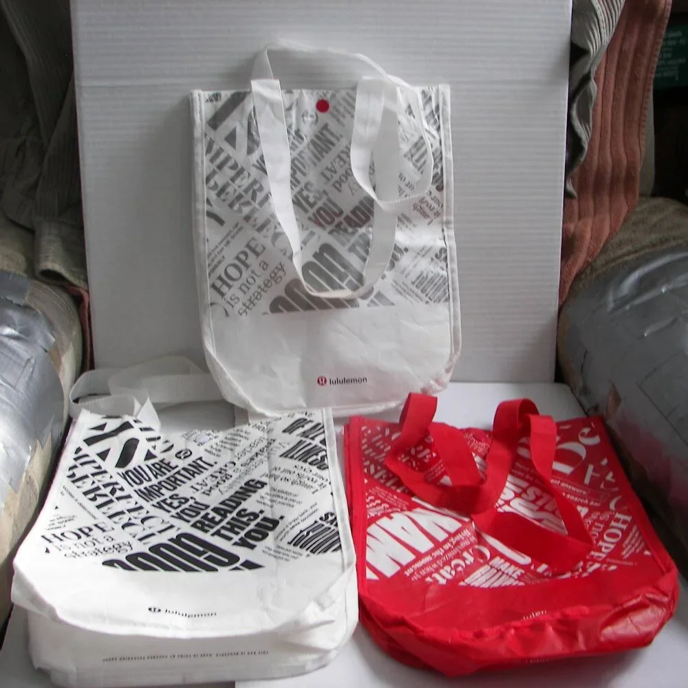 Three Lululemon nylon gift bags with snap closure - -  two white, one red